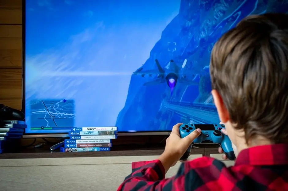 pemain muda sedang bermain game mobile di depan laptop dengan latar pegunungan Arfak